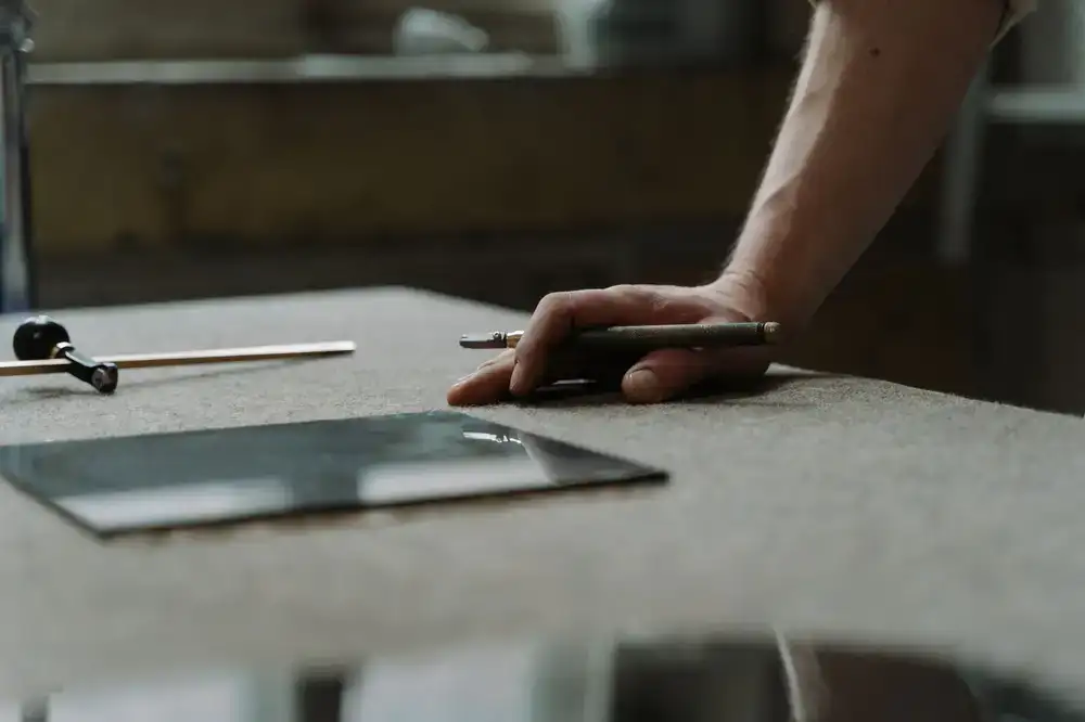Artisan cutting glass using a specialized hand tool
