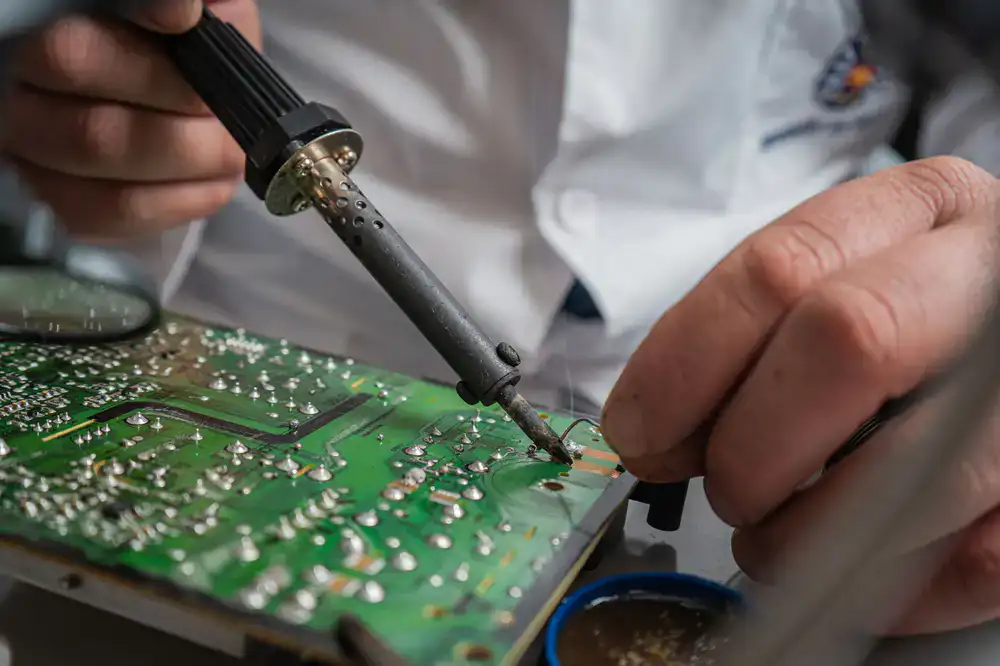 Close up of a soldering iron joining lead came joints on a glass panel