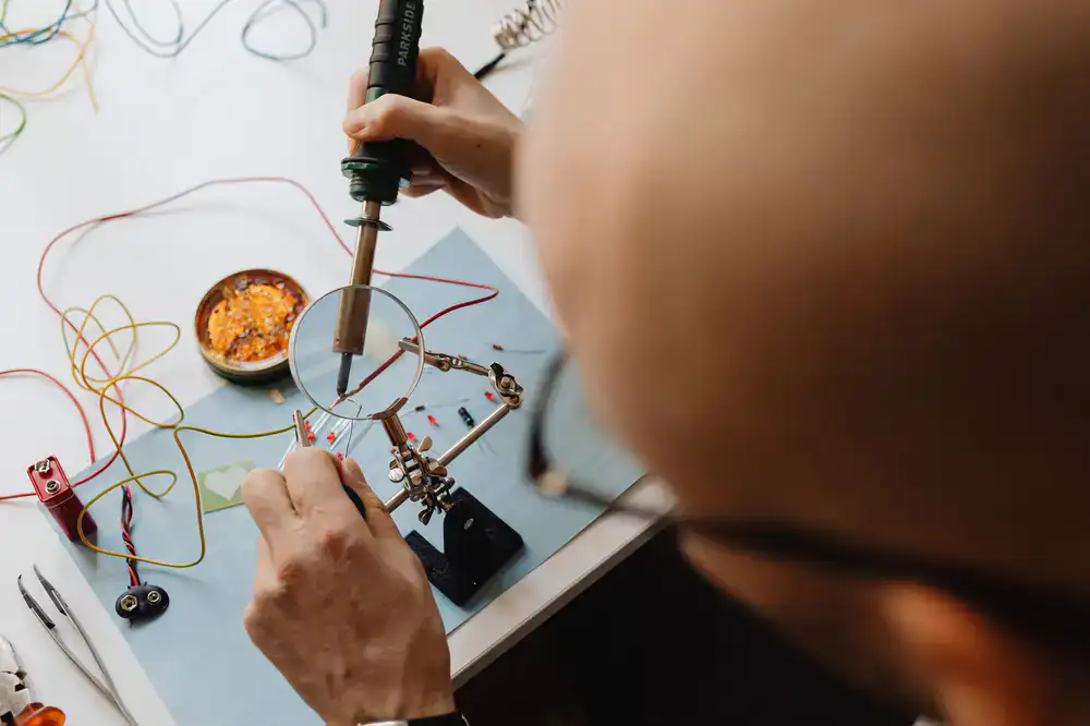 Close-up of a student soldering a stained glass panel